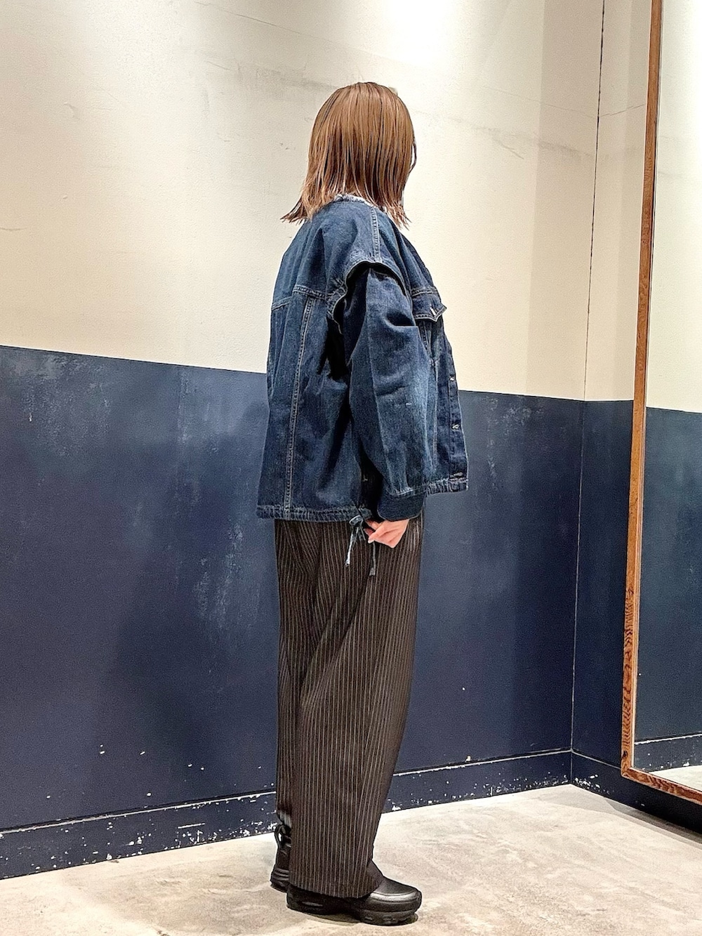 ブルー系のデニムジャケット、グレー系のスラックス、グレー系のスウェットを着用したレディースの冬コーディネートの2枚目の写真