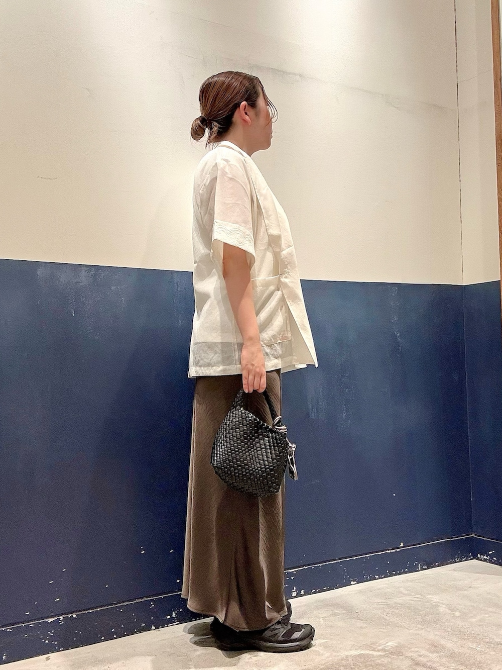 ブラック系のショルダーバッグ、グレー系のスカート、ホワイト系のTシャツ/カットソーを着用したレディースの夏コーディネートの2枚目の写真