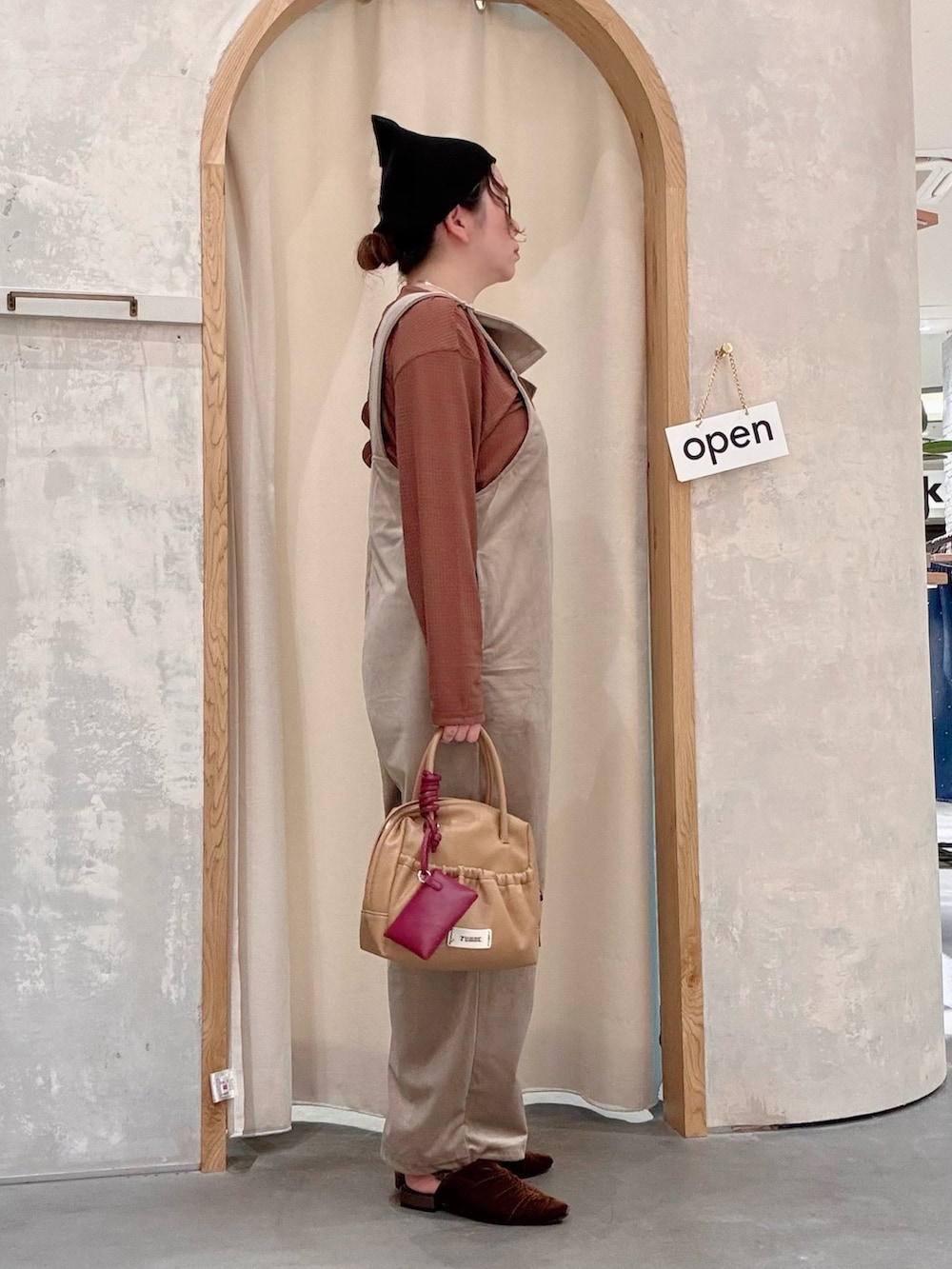 ブラウン系のパンプス、イエロー系のショルダーバッグ、ブラウン系のTシャツ/カットソーを着用したレディースの秋コーディネートの2枚目の写真