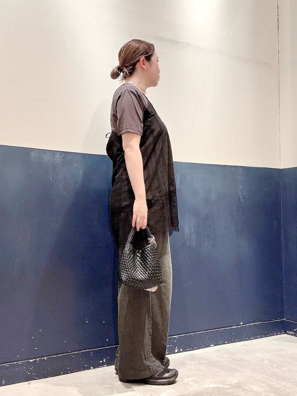 ブラック系のデニムパンツ、ブラック系のショルダーバッグ、ブラック系のチュニックを着用したレディースの夏コーディネートの2枚目の写真