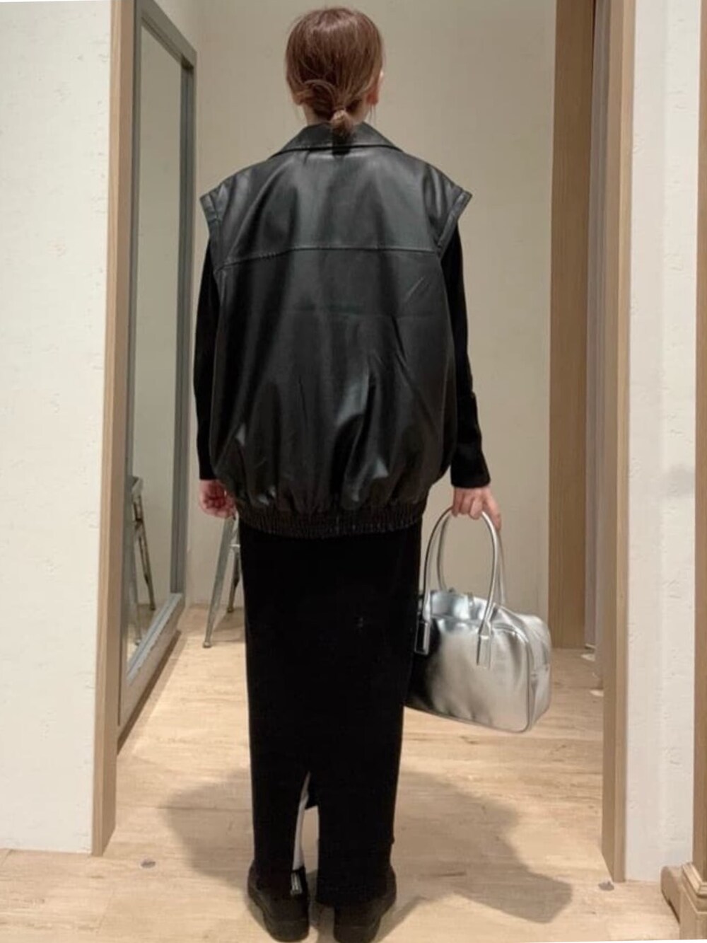 ブラック系のライダースジャケット、ブラック系のワンピース、シルバー系のボストンバッグを着用したレディースの秋コーディネートの3枚目の写真