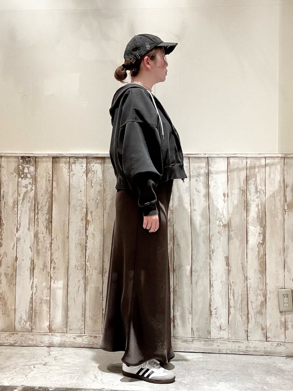 グレー系のスカート、グレー系のパーカー、ホワイト系のTシャツ/カットソーを着用したレディースの春コーディネートの2枚目の写真