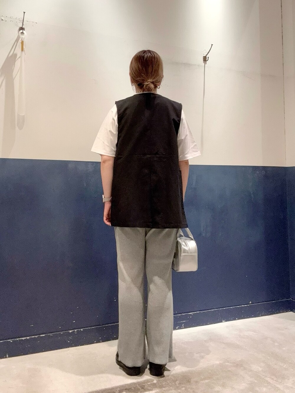 ホワイト系のTシャツ/カットソー、ブラック系のベスト、シルバー系のショルダーバッグを着用したレディースの春コーディネートの3枚目の写真