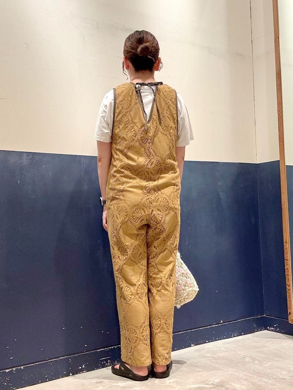ホワイト系のショルダーバッグ、ホワイト系のTシャツ/カットソー、イエロー系のサロペット/オーバーオールを着用したレディースの夏コーディネートの3枚目の写真