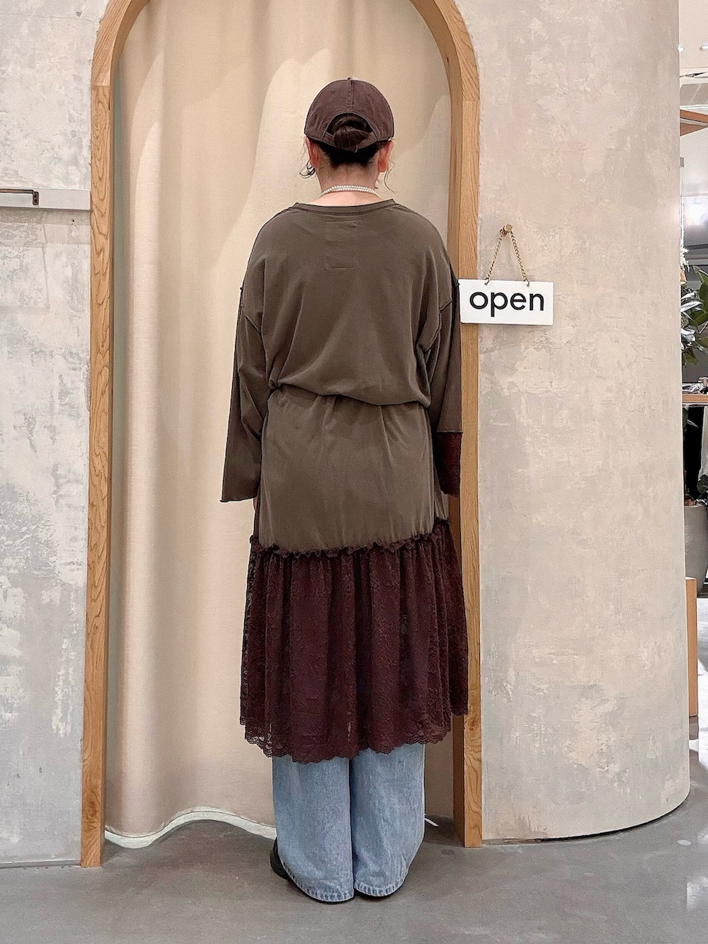ブルー系のデニムパンツ、ブラウン系のボディバッグ/ウエストポーチ、ブラウン系のワンピースを着用したレディースの秋コーディネートの3枚目の写真