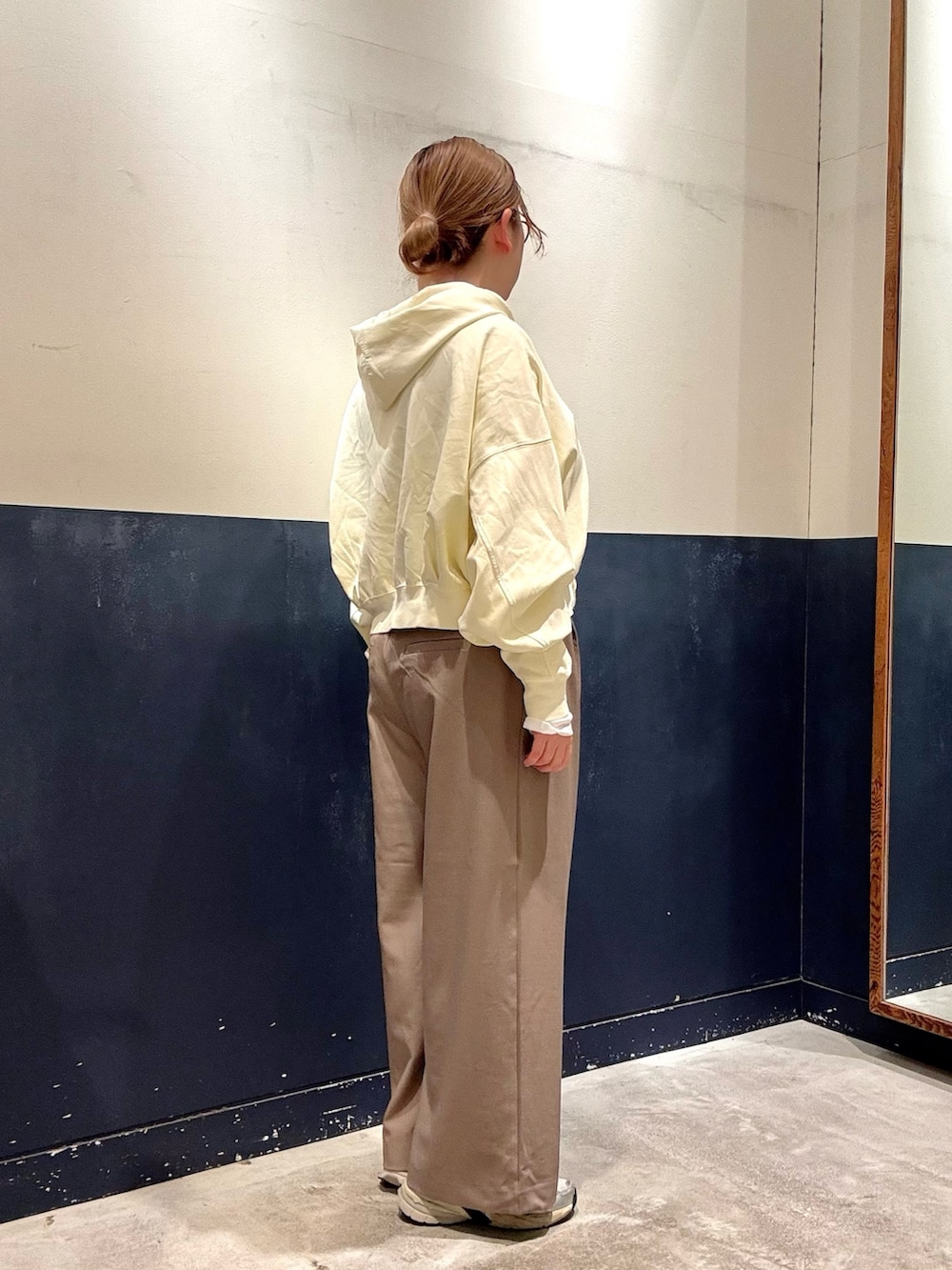 ベージュ系のスラックス、イエロー系のパーカー、ホワイト系のTシャツ/カットソーを着用したレディースの春コーディネートの2枚目の写真