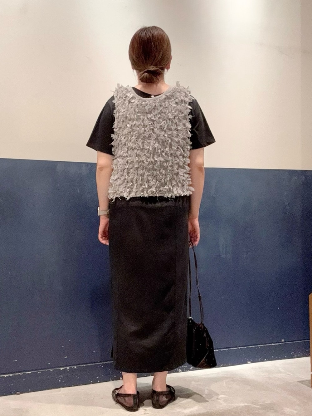 ブラック系のワンピース、ブラック系のパンプス、グレー系のベストを着用したレディースの夏コーディネートの3枚目の写真