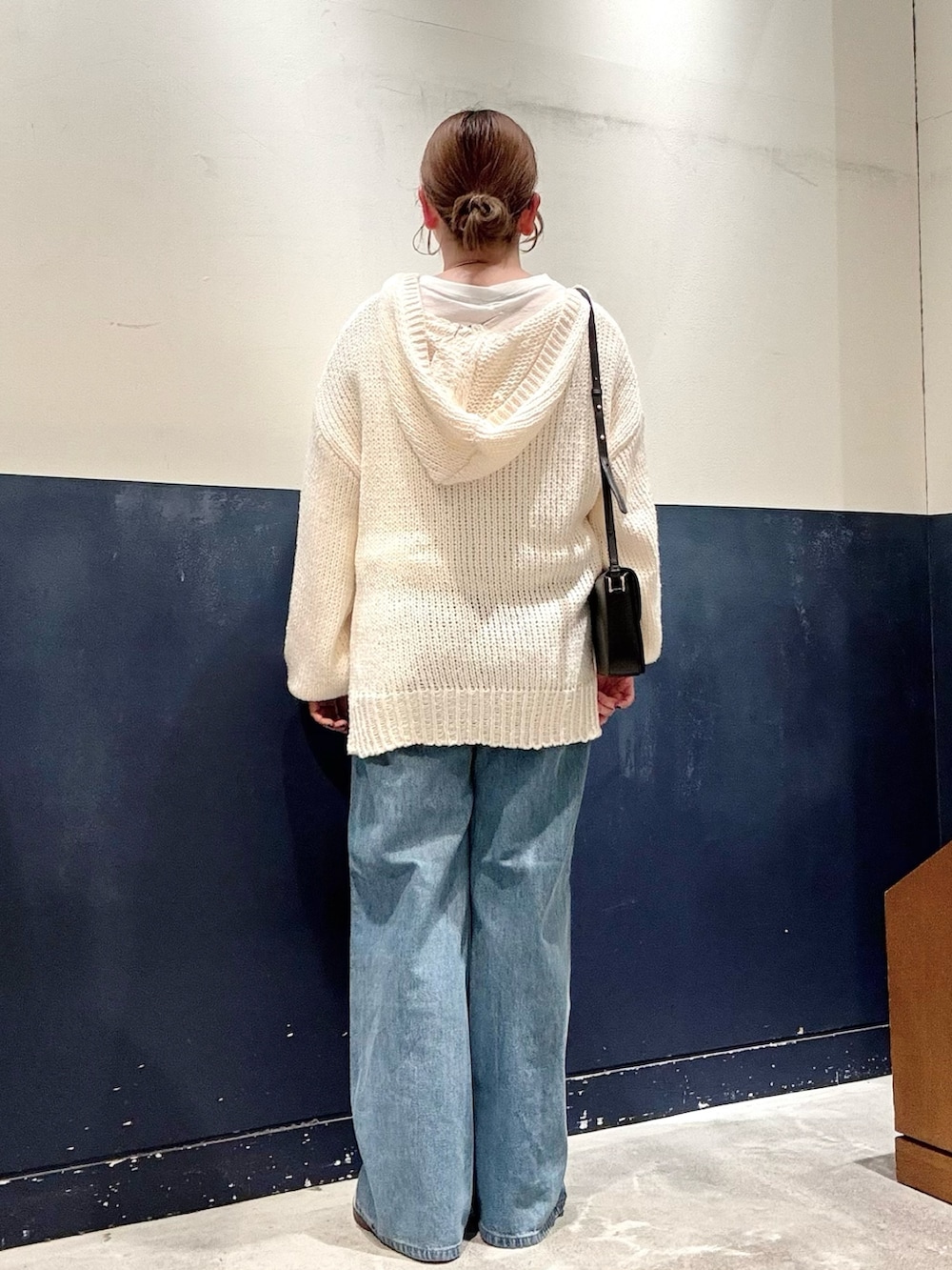 ホワイト系のTシャツ/カットソー、ブルー系のデニムパンツ、ブラック系のショルダーバッグを着用したレディースの秋コーディネートの3枚目の写真