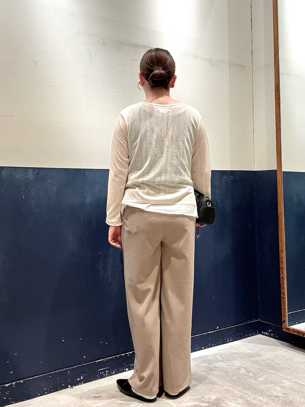 ブラック系のパンプス、ブラック系のショルダーバッグ、イエロー系のカーディガン/ボレロを着用したレディースの春コーディネートの3枚目の写真