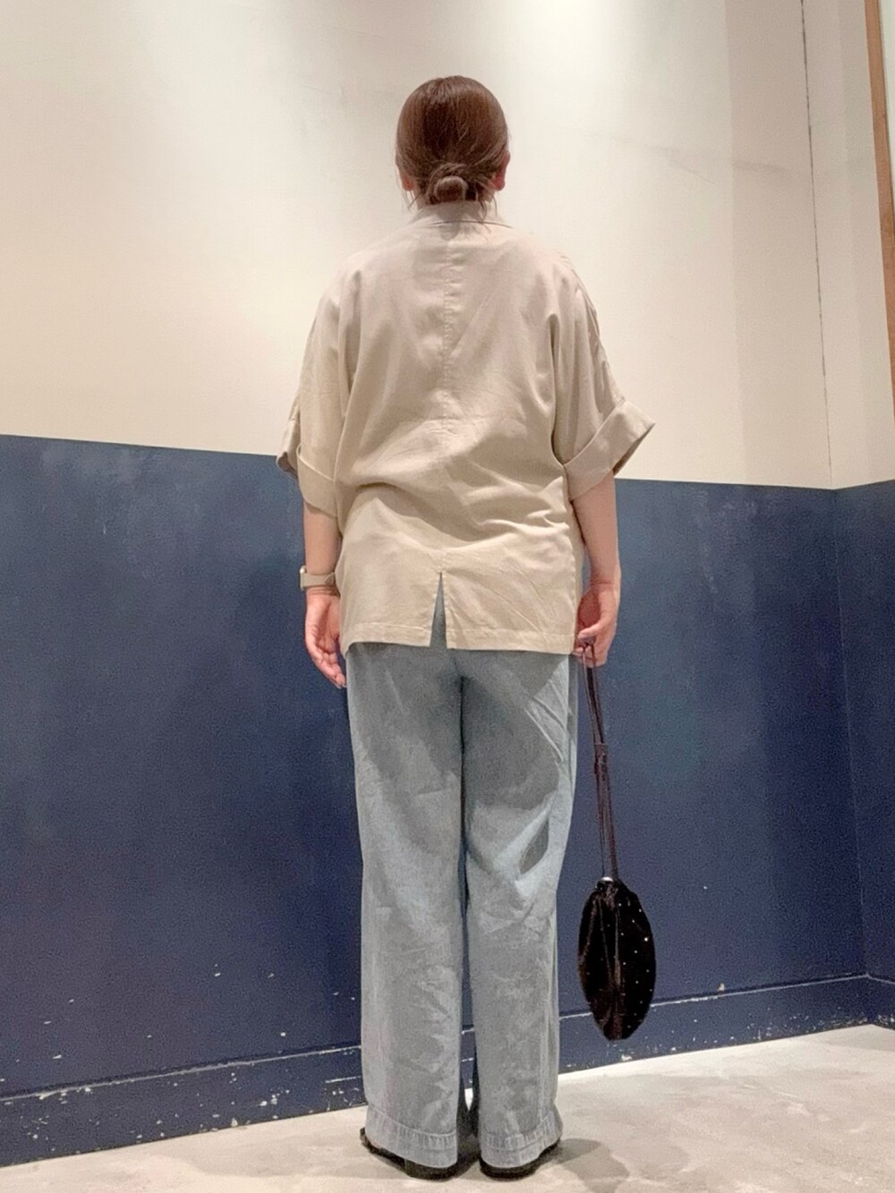 ベージュ系のテーラードジャケット、ブラウン系のTシャツ/カットソー、ブルー系のデニムパンツを着用したレディースの夏コーディネートの3枚目の写真