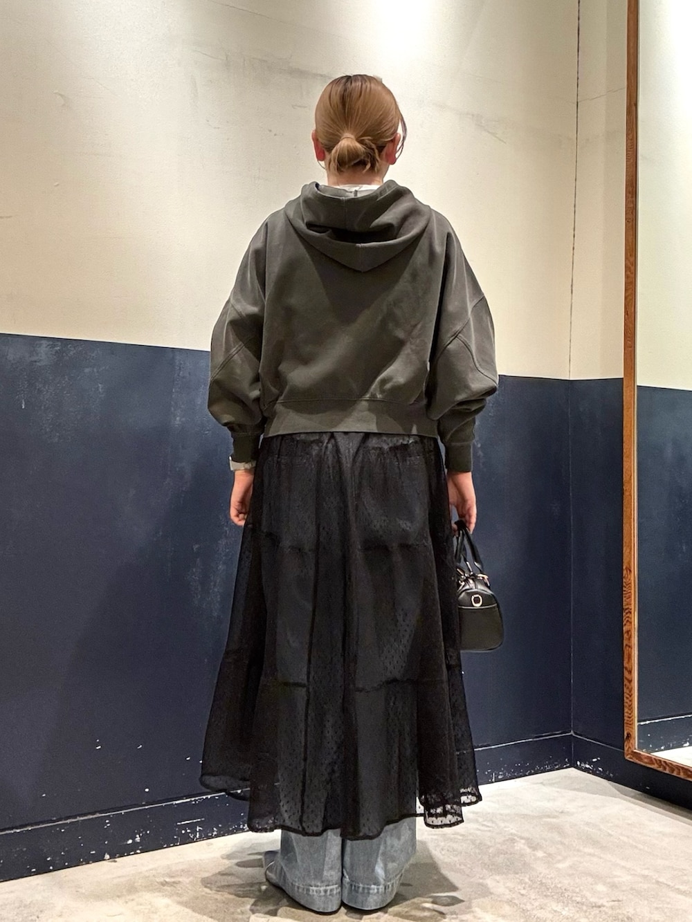 ブラック系のワンピース、ブラック系のショルダーバッグ、シルバー系のパンプスを着用したレディースの春コーディネートの3枚目の写真