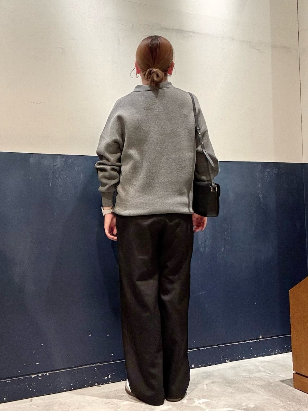 ブラック系のスラックス、グレー系のニット/セーター、ブラック系のショルダーバッグを着用したレディースの秋コーディネートの3枚目の写真