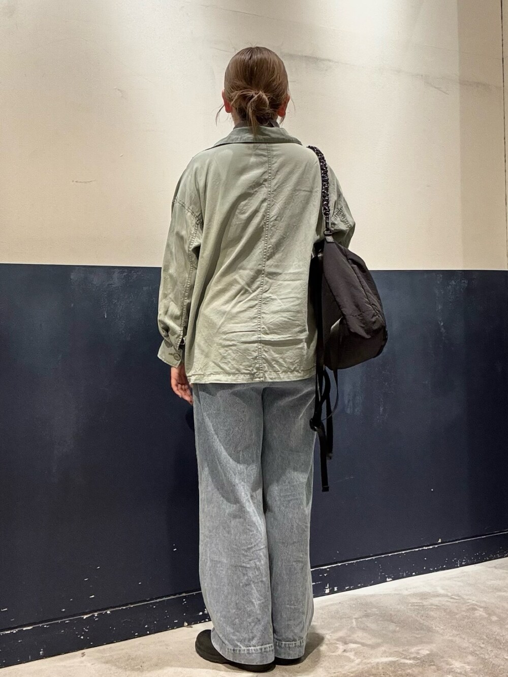 グリーン系のシャツ/ブラウス、ブラック系のトートバッグ、ブルー系のデニムパンツを着用したレディースの冬コーディネートの3枚目の写真