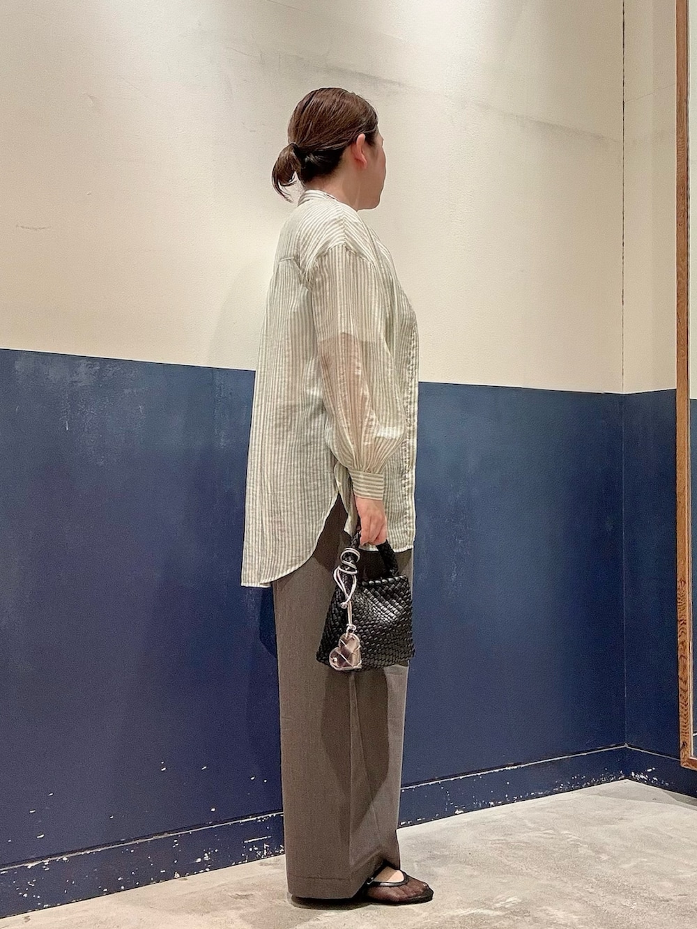 グレー系のデニムパンツ、ブラック系のショルダーバッグ、ブラック系のパンプスを着用したレディースの夏コーディネートの2枚目の写真