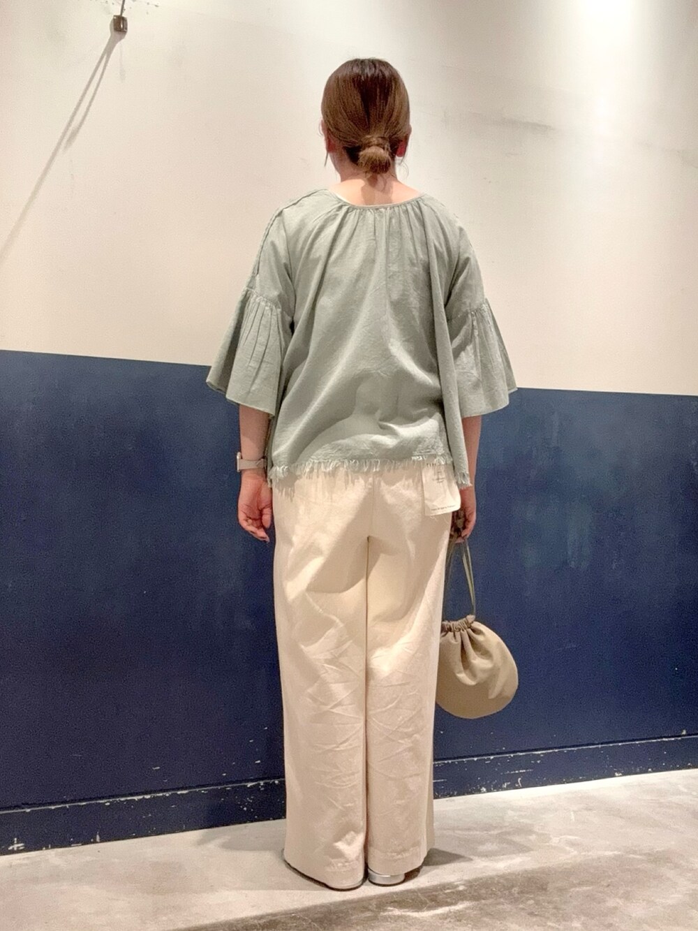 シルバー系のサンダル、グリーン系のハンドバッグ、グレー系のタンクトップを着用したレディースの夏コーディネートの3枚目の写真