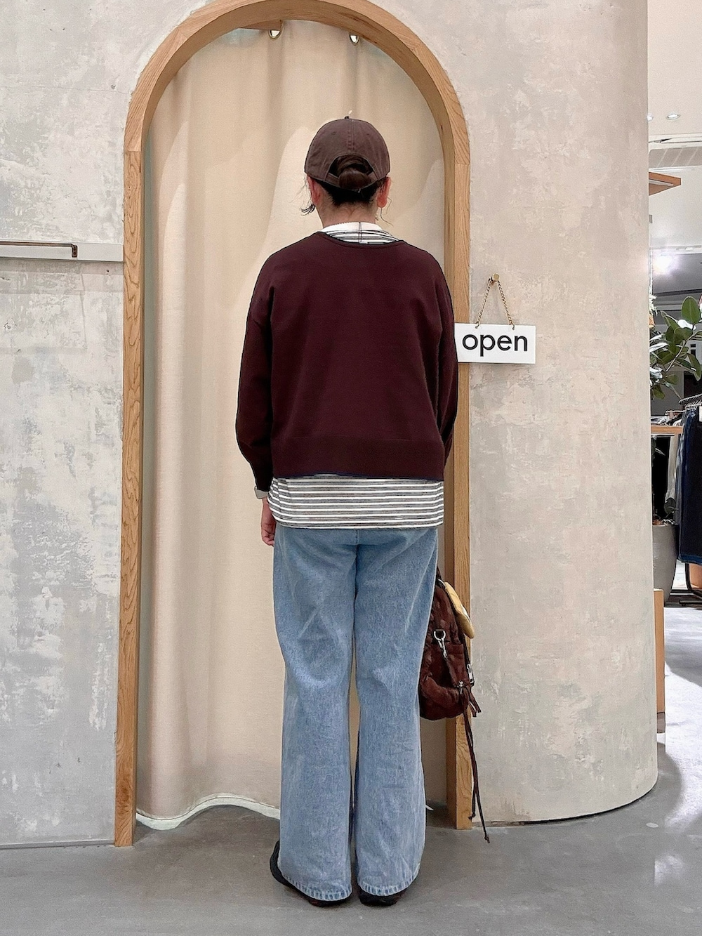 ブルー系のデニムパンツ、ブラウン系のカーディガン/ボレロ、ホワイト系のTシャツ/カットソーを着用したレディースの秋コーディネートの3枚目の写真