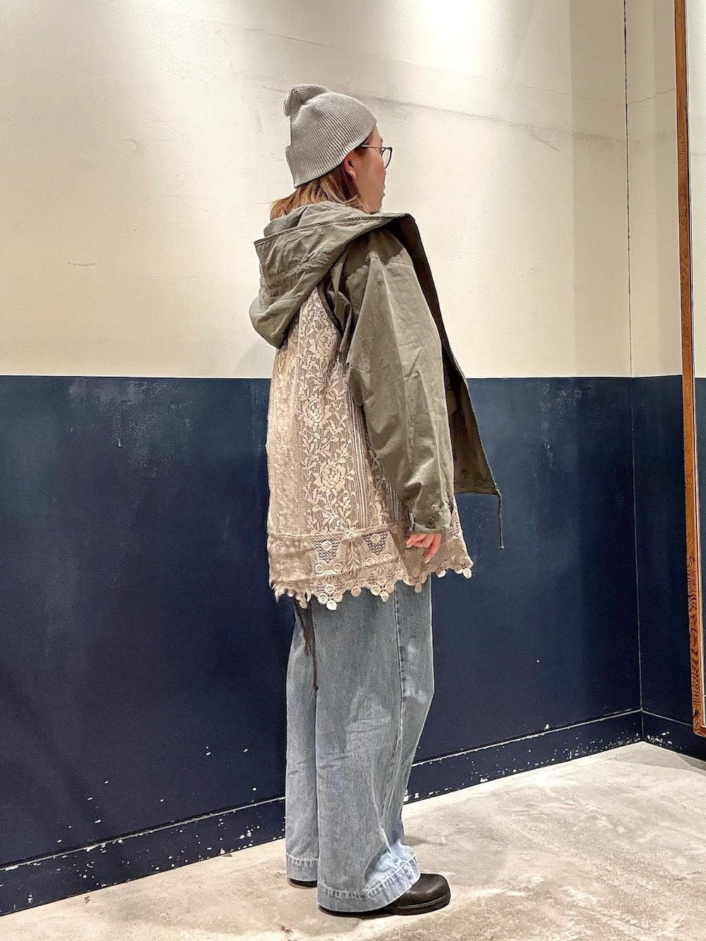 ホワイト系のニット/セーター、グリーン系のその他アウター、ブルー系のデニムパンツを着用したレディースの冬コーディネートの2枚目の写真