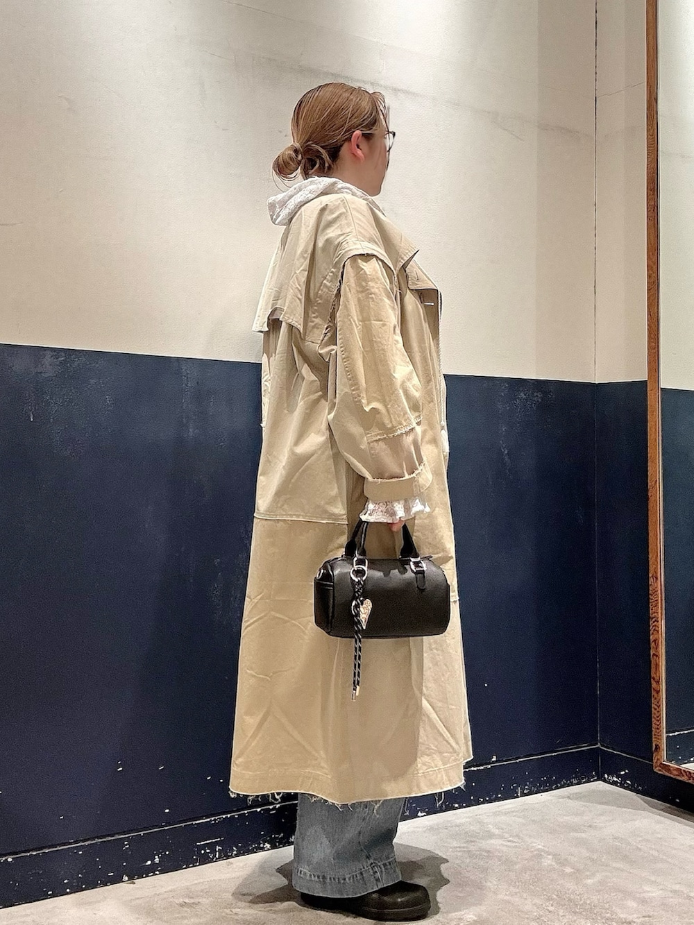ホワイト系のシャツ/ブラウス、ベージュ系のトレンチコート、ブルー系のデニムパンツを着用したレディースの春コーディネートの2枚目の写真