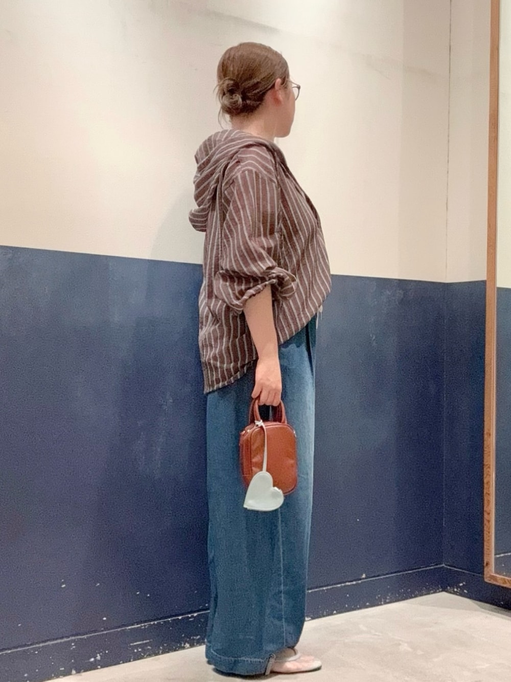 ブラウン系のタンクトップ、ブラウン系のトートバッグ、ブルー系のパンプスを着用したレディースの夏コーディネートの2枚目の写真