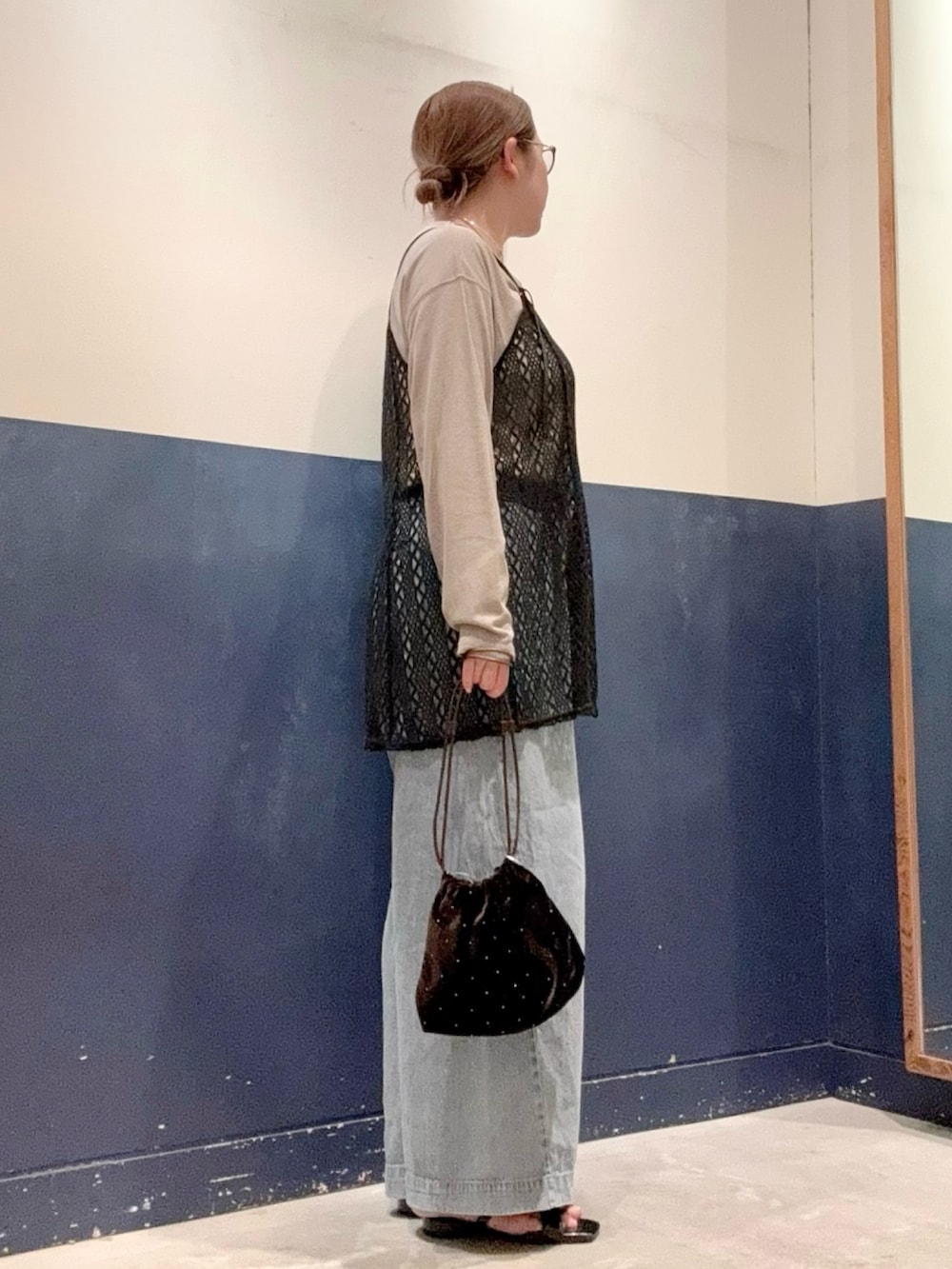ブラック系のサンダル、ブルー系のデニムパンツ、ベージュ系のTシャツ/カットソーを着用したレディースの夏コーディネートの2枚目の写真