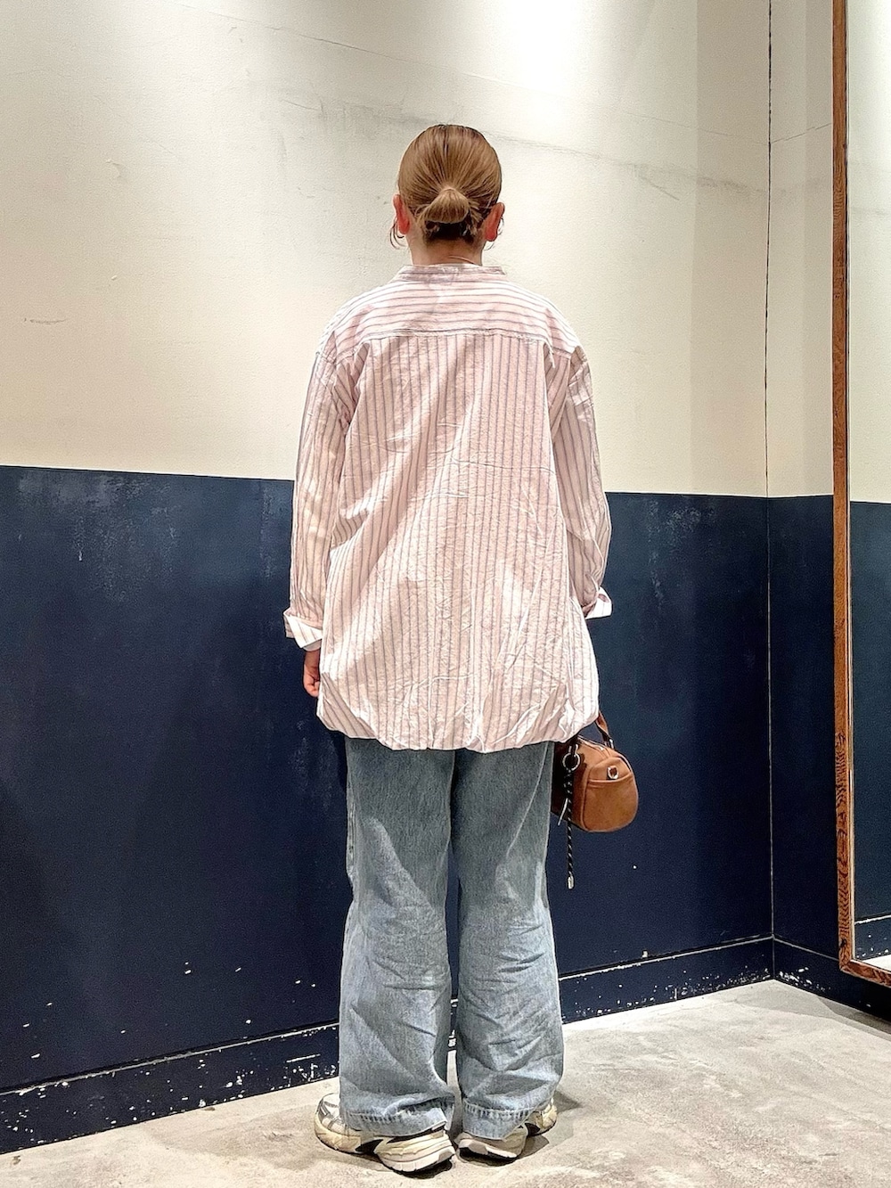 ベージュ系のショルダーバッグ、ブルー系のデニムパンツ、ピンク系のシャツ/ブラウスを着用したレディースの春コーディネートの3枚目の写真