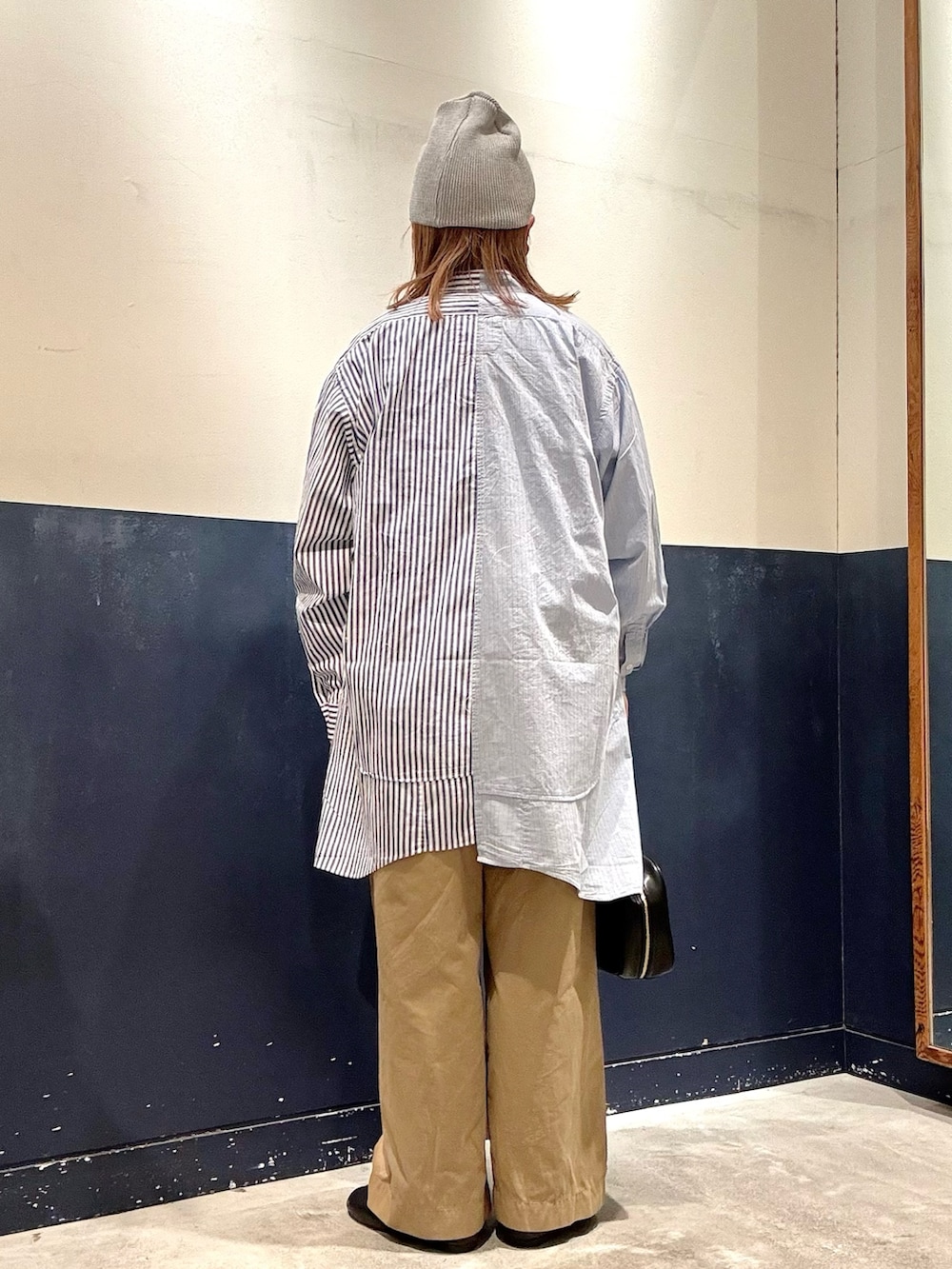 ブラック系のボストンバッグ、ベージュ系のデニムパンツ、ブルー系のシャツ/ブラウスを着用したレディースの冬コーディネートの3枚目の写真