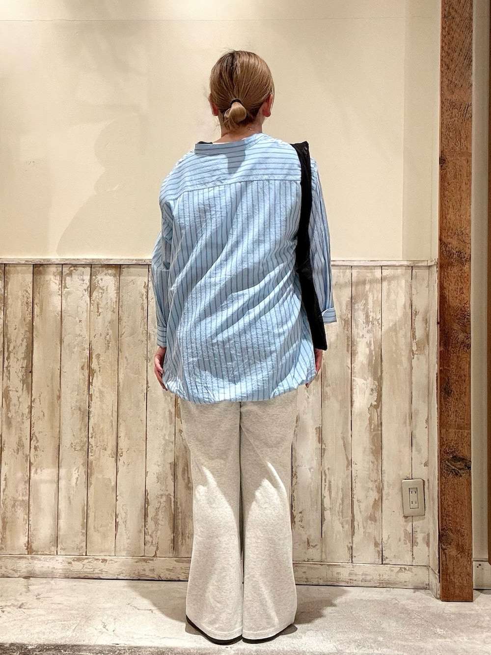 ブラック系のトートバッグ、ブルー系のシャツ/ブラウス、ブラック系のタンクトップを着用したレディースの春コーディネートの3枚目の写真