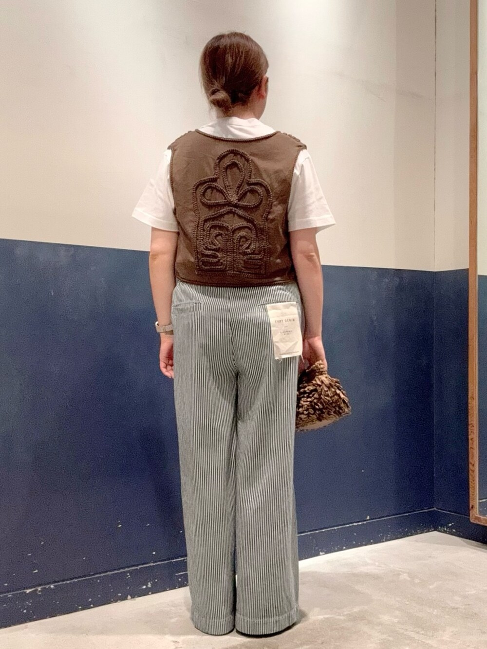 グレー系のTシャツ/カットソー、ブラウン系のベスト、ブラウン系のショルダーバッグを着用したレディースの夏コーディネートの3枚目の写真