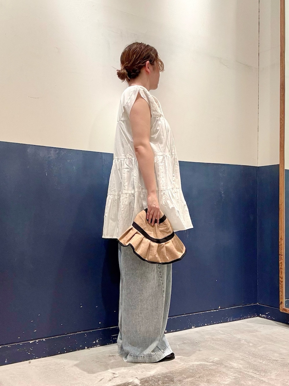 ブルー系のデニムパンツ、イエロー系のサンダル、ホワイト系のシャツ/ブラウスを着用したレディースの夏コーディネートの2枚目の写真