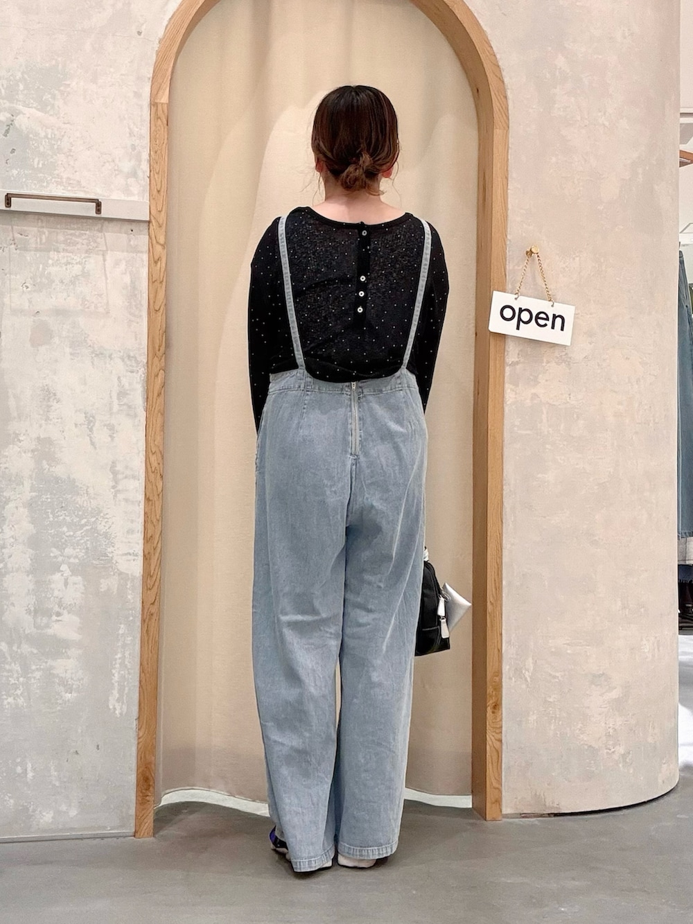 ブラック系のショルダーバッグ、ブルー系のサロペット/オーバーオール、ブラック系のTシャツ/カットソーを着用したレディースの夏コーディネートの3枚目の写真