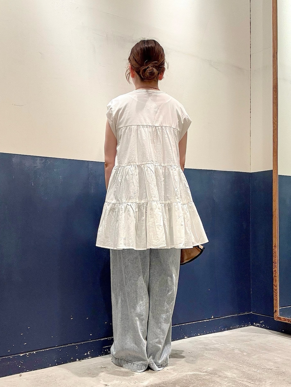 ブルー系のデニムパンツ、イエロー系のサンダル、ホワイト系のシャツ/ブラウスを着用したレディースの夏コーディネートの3枚目の写真