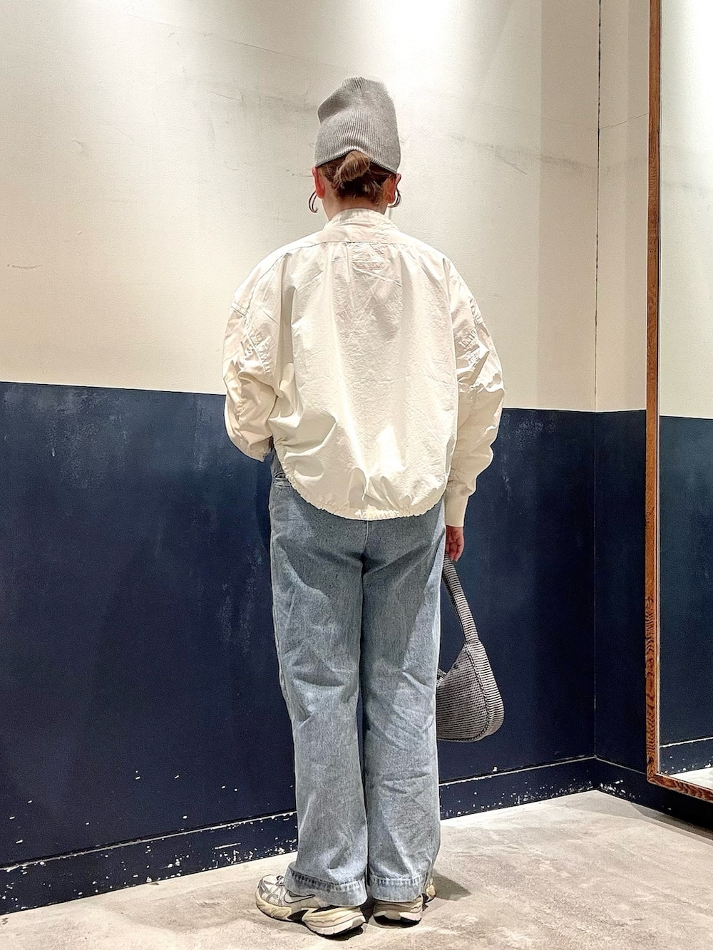 ホワイト系のシャツ/ブラウス、ブラック系のショルダーバッグ、ブルー系のデニムパンツを着用したレディースの春コーディネートの3枚目の写真