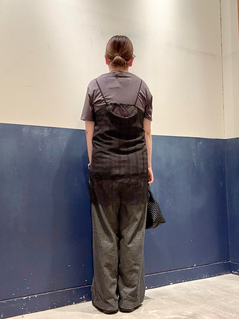 ブラック系のデニムパンツ、ブラック系のショルダーバッグ、ブラック系のチュニックを着用したレディースの夏コーディネートの3枚目の写真