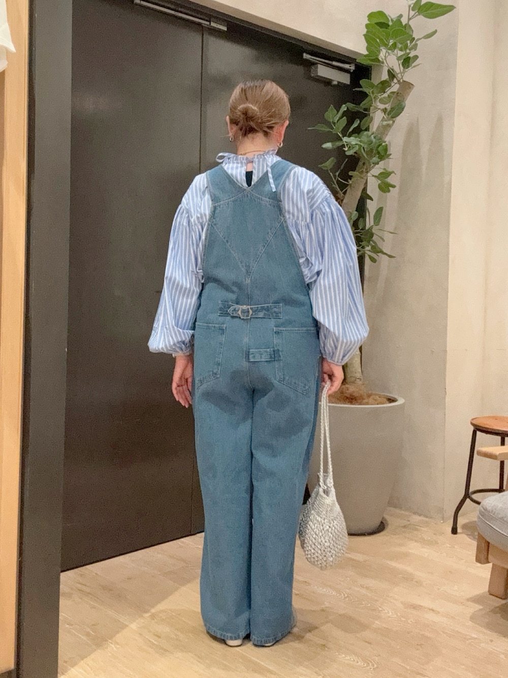 ブルー系のサロペット/オーバーオール、ブルー系のシャツ/ブラウス、グレー系のサンダルを着用したレディースの春コーディネートの3枚目の写真