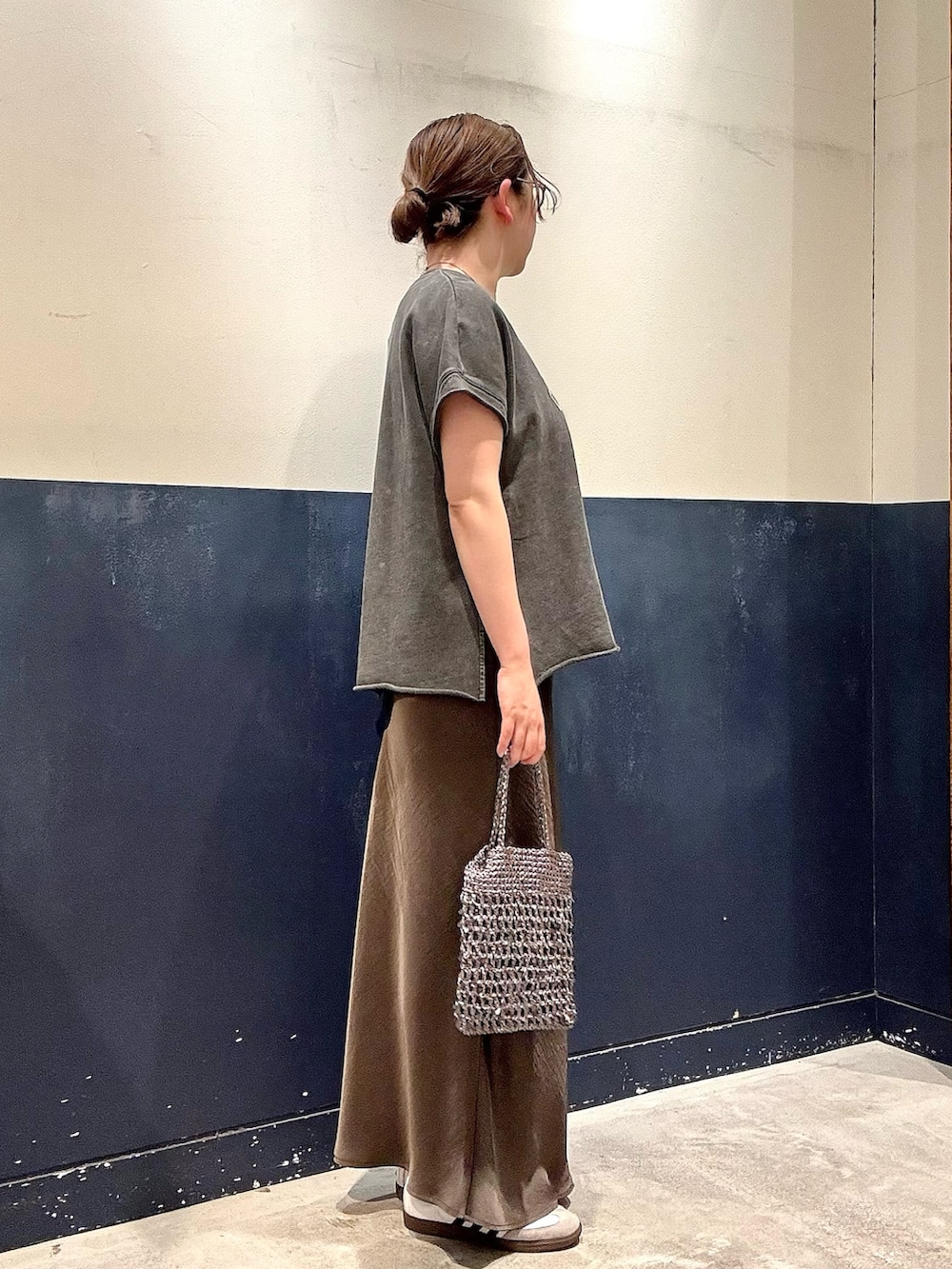 グレー系のTシャツ/カットソー、グレー系のスカート、グレー系のショルダーバッグを着用したレディースの春コーディネートの2枚目の写真