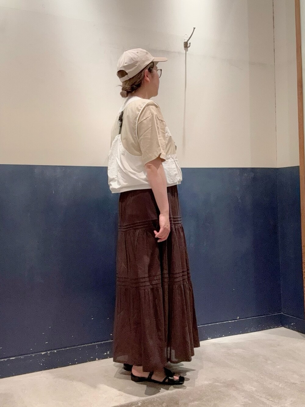 ベージュ系のTシャツ/カットソー、ホワイト系のベスト、ブラウン系のスカートを着用したレディースの春コーディネートの2枚目の写真