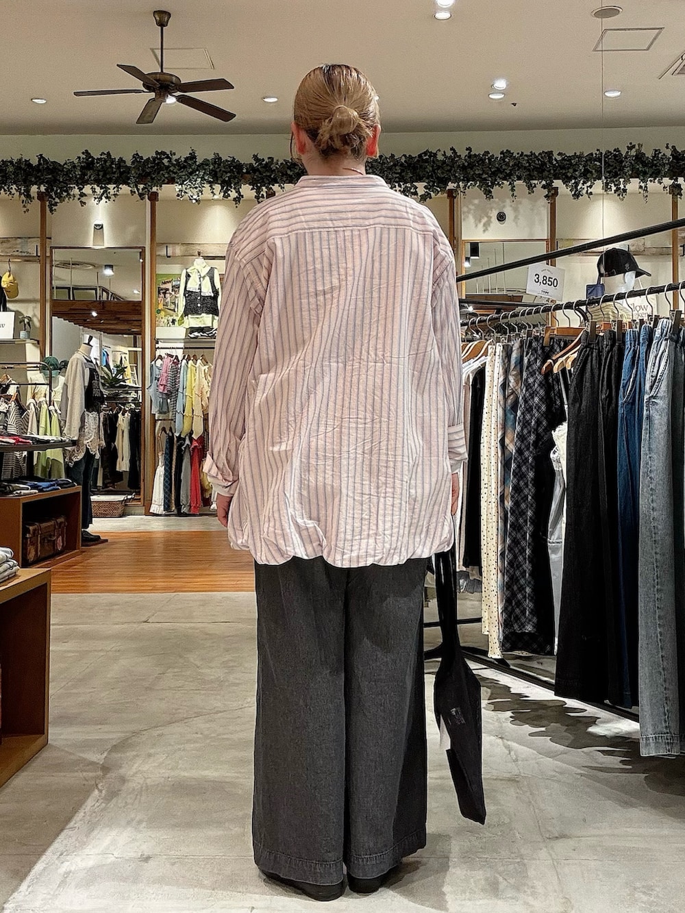 ブラック系のトートバッグ、ブラック系のデニムパンツ、ピンク系のシャツ/ブラウスを着用したレディースの春コーディネートの3枚目の写真