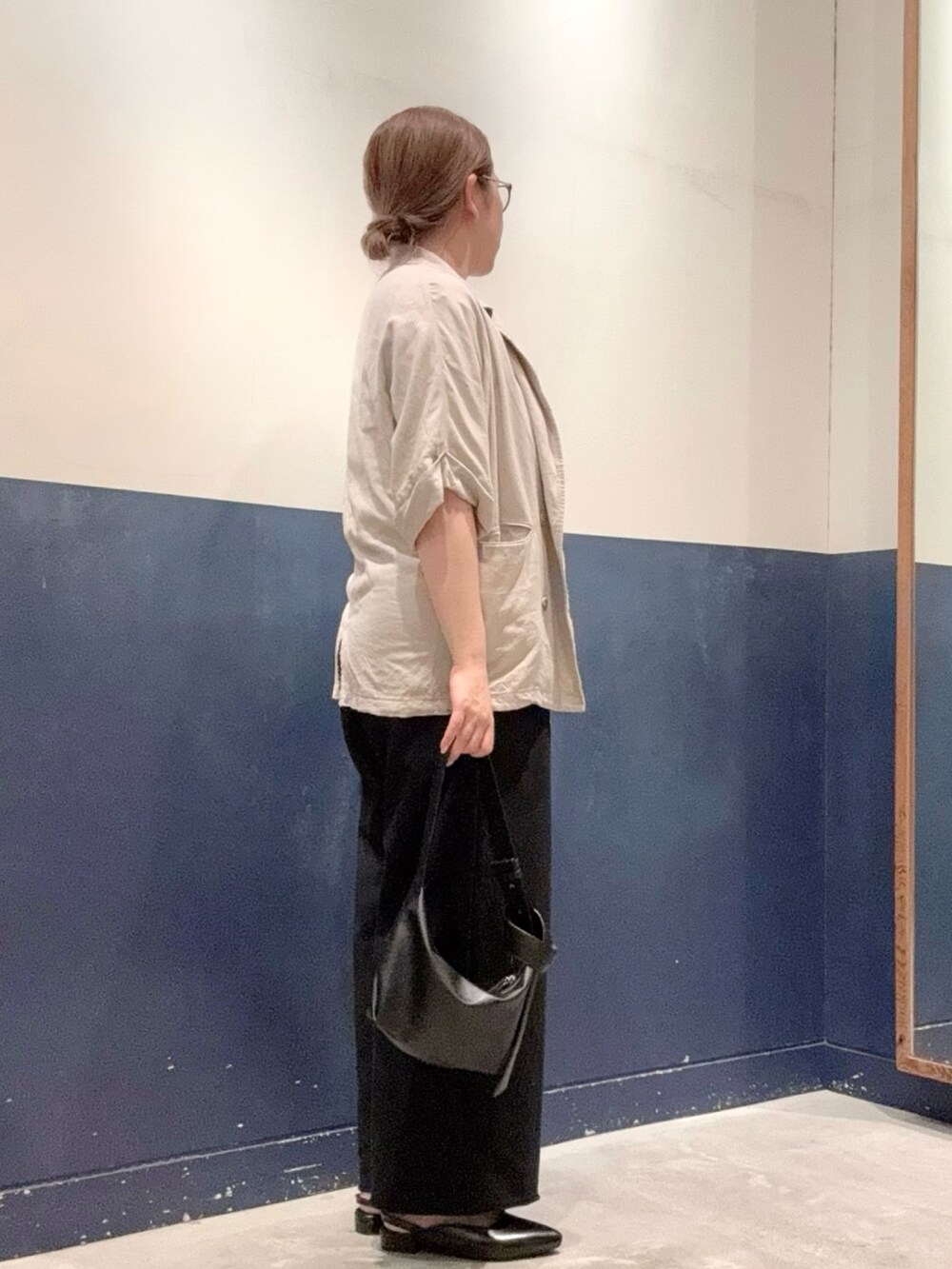ブラック系のパンプス、ブラック系のショルダーバッグ、ブラック系のスウェットパンツを着用したレディースの夏コーディネートの2枚目の写真
