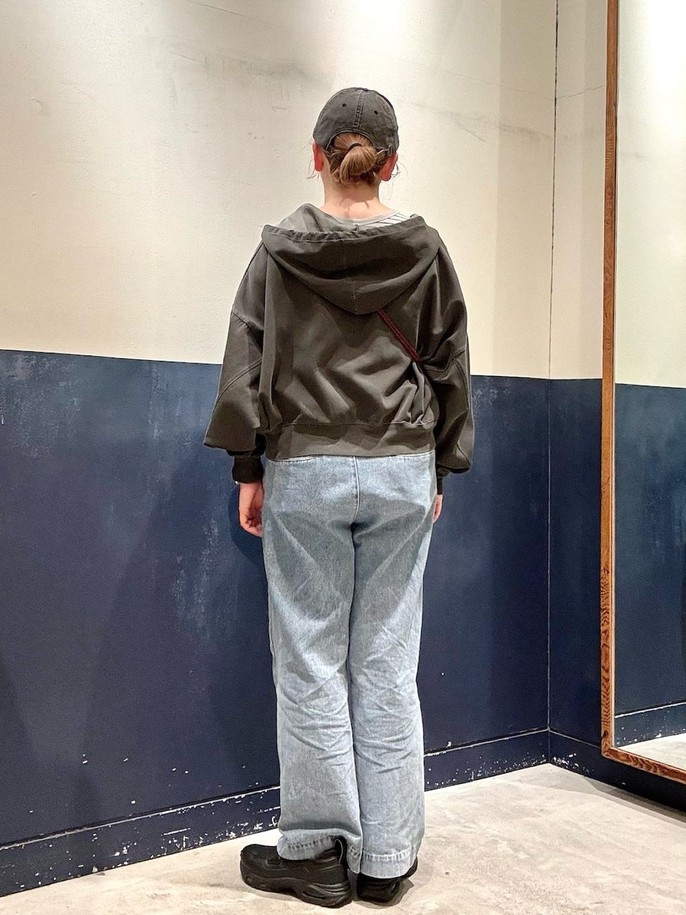 ブルー系のデニムパンツ、ブラック系のショルダーバッグ、グレー系のTシャツ/カットソーを着用したレディースの春コーディネートの3枚目の写真