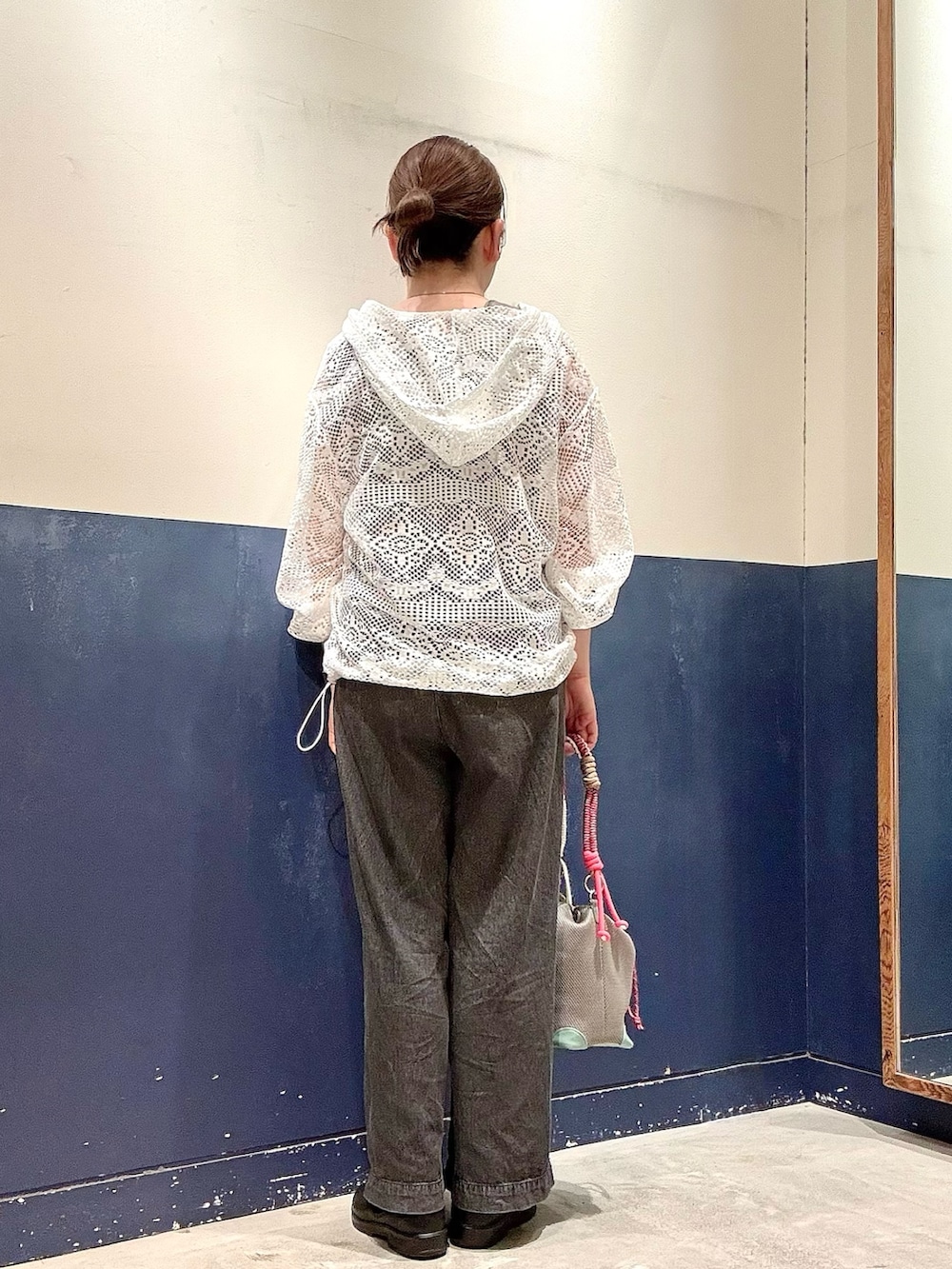 グレー系のショルダーバッグ、ブラック系のデニムパンツ、ホワイト系のその他アウターを着用したレディースの夏コーディネートの3枚目の写真