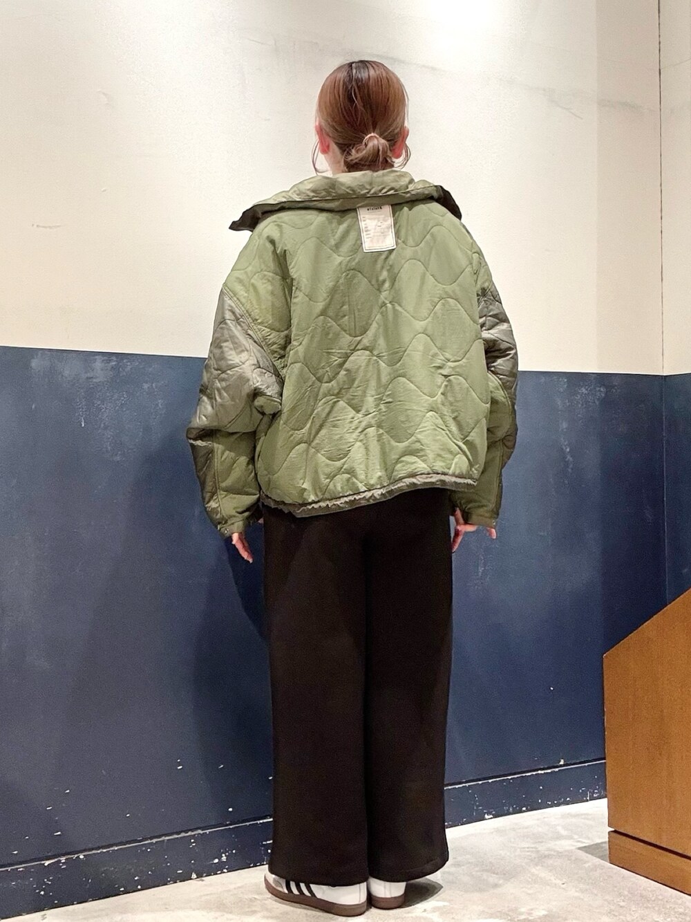 ブラック系のその他パンツ、グリーン系のダウンジャケット/コート、ホワイト系のTシャツ/カットソーを着用したレディースの秋コーディネートの3枚目の写真