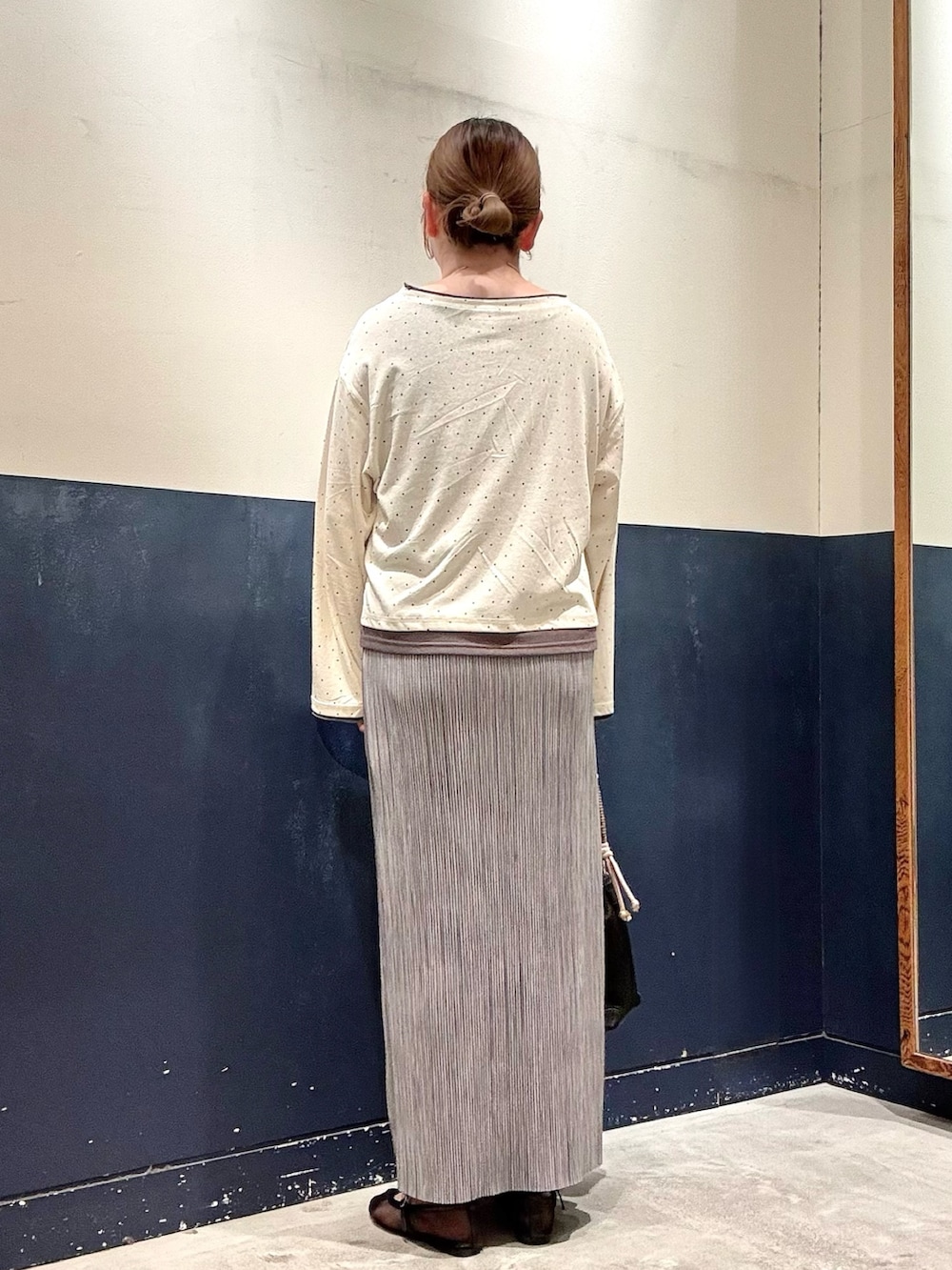 ブラック系のパンプス、ブラック系のショルダーバッグ、グレー系のスカートを着用したレディースの春コーディネートの3枚目の写真