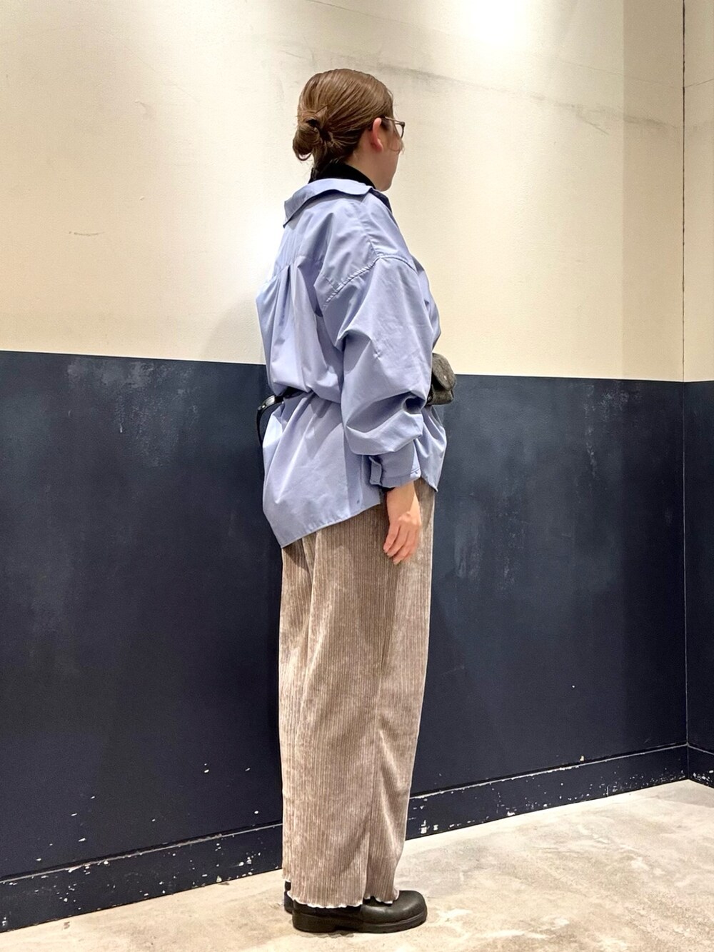 ブラック系のニット/セーター、ブルー系のシャツ/ブラウス、グレー系のボディバッグ/ウエストポーチを着用したレディースの冬コーディネートの2枚目の写真