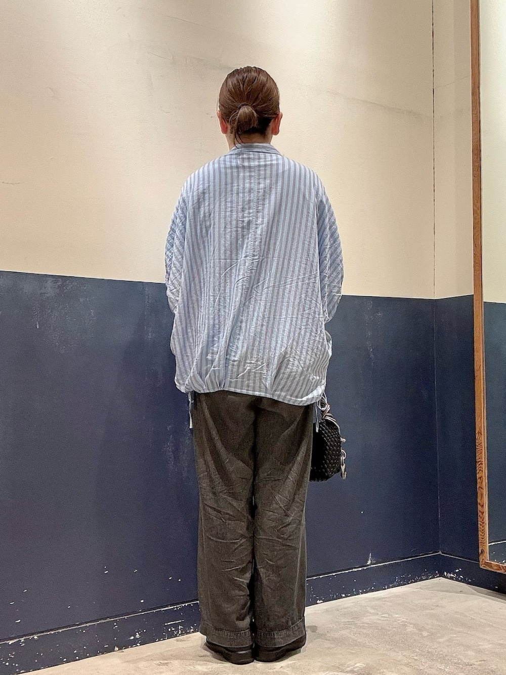 ブラック系のショルダーバッグ、ブラック系のデニムパンツ、ブルー系のシャツ/ブラウスを着用したレディースの夏コーディネートの3枚目の写真