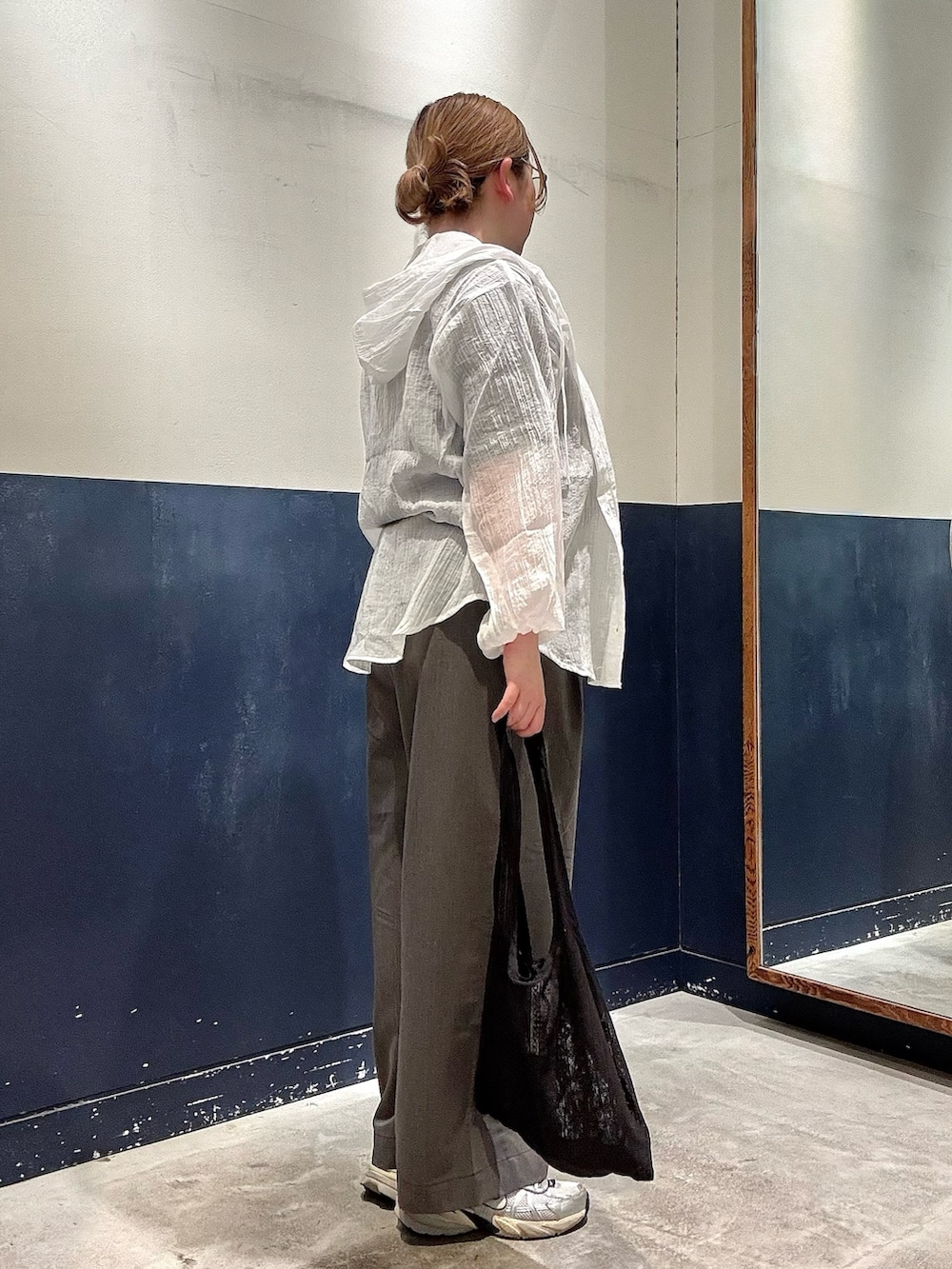 グレー系のデニムパンツ、ブラック系のTシャツ/カットソー、ブラック系のトートバッグを着用したレディースの春コーディネートの2枚目の写真