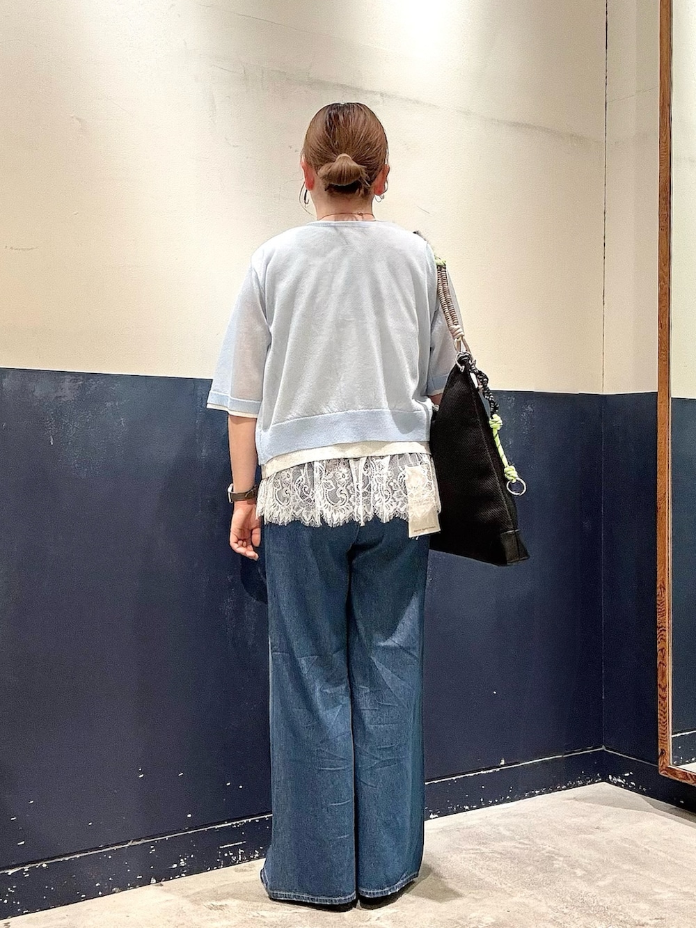 ブラック系のパンプス、ブルー系のデニムパンツ、ブラック系のショルダーバッグを着用したレディースの春コーディネートの3枚目の写真