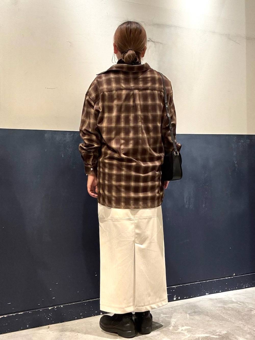 ホワイト系のスカート、ブラック系のショルダーバッグ、ブラウン系のシャツ/ブラウスを着用したレディースの秋コーディネートの3枚目の写真