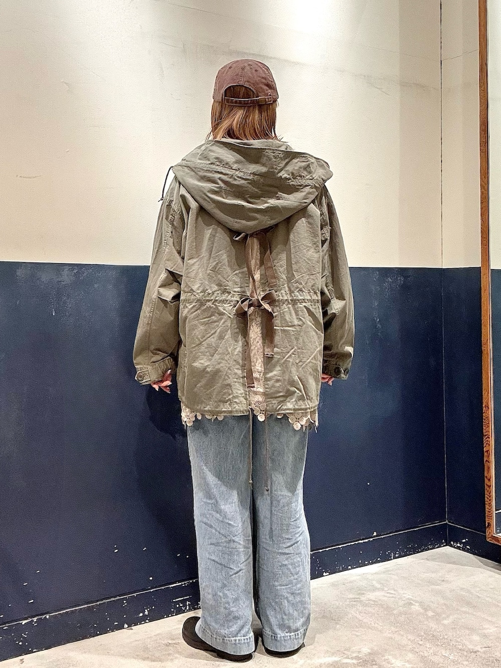 ブルー系のデニムパンツ、ホワイト系のキャミソール、イエロー系のスウェットを着用したレディースの冬コーディネートの3枚目の写真