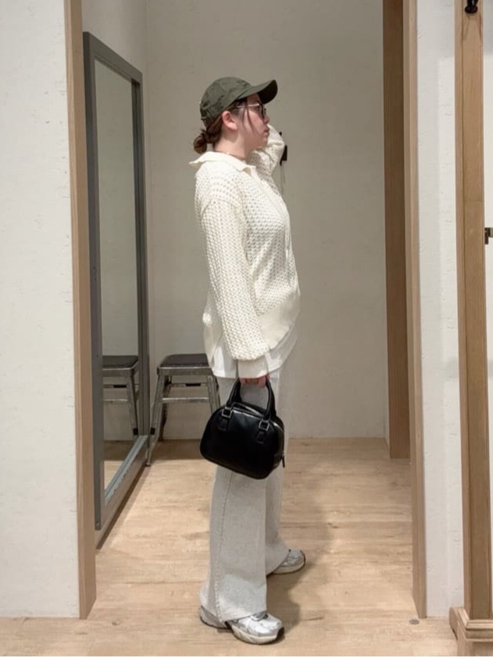 ホワイト系のニット/セーター、ホワイト系のTシャツ/カットソー、ブラック系のショルダーバッグを着用したレディースの春コーディネートの2枚目の写真