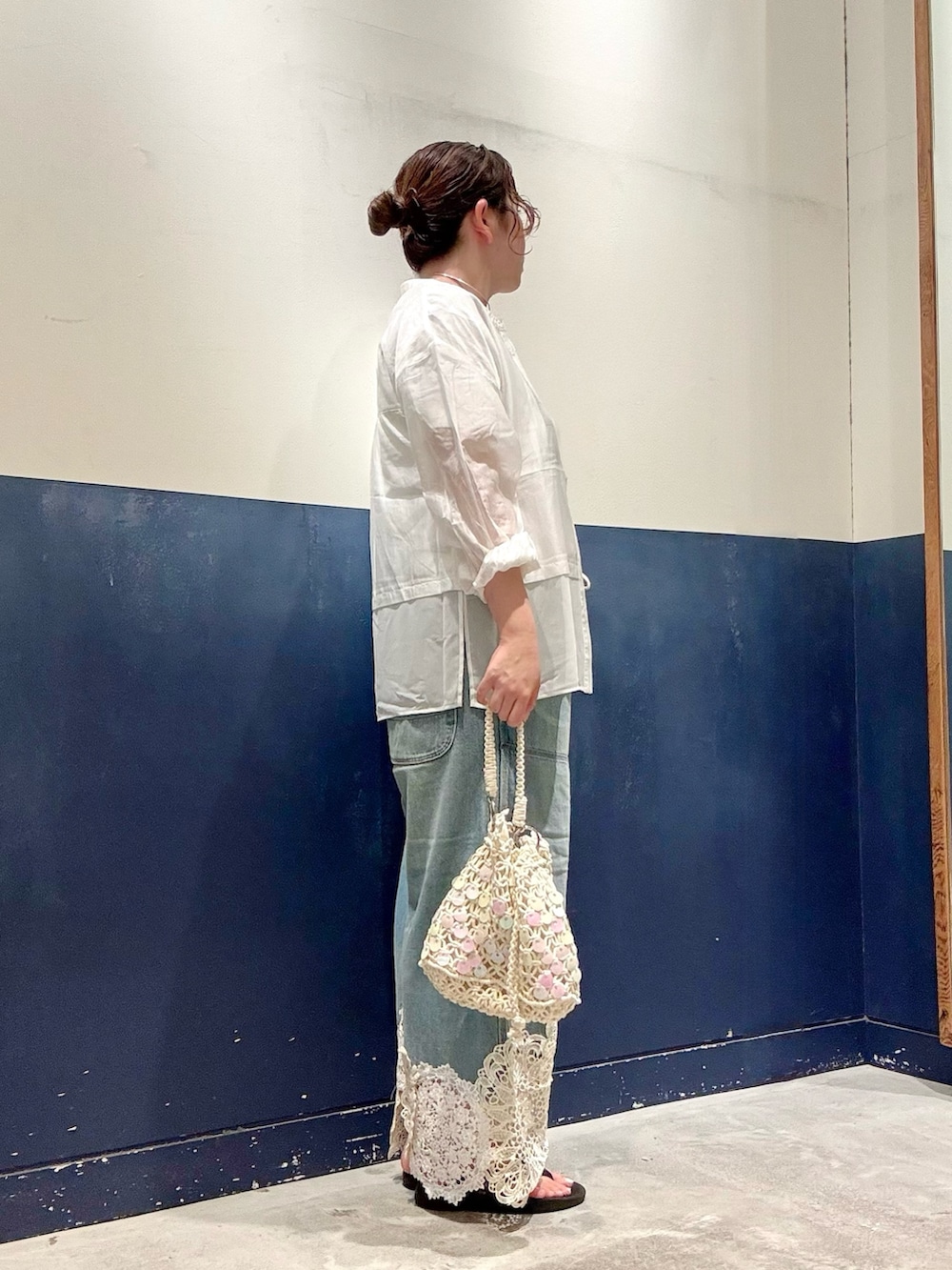 ブルー系のデニムパンツ、ホワイト系のショルダーバッグ、ホワイト系のTシャツ/カットソーを着用したレディースの夏コーディネートの2枚目の写真